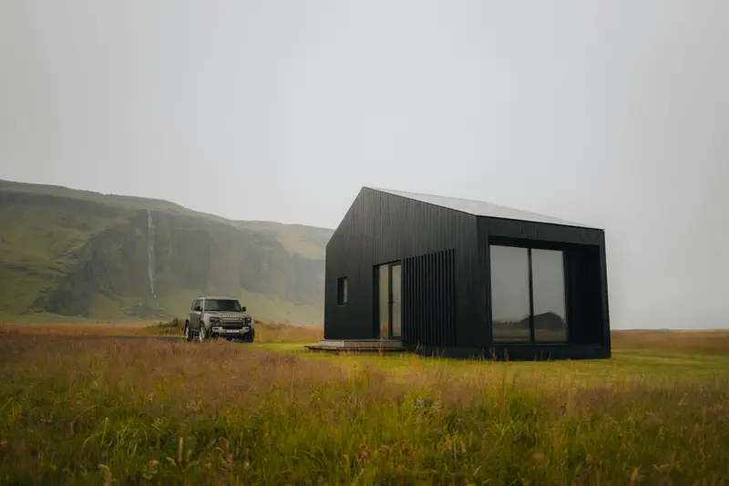 Tamsus vieno modulio namelis su dideliu langu pievoje